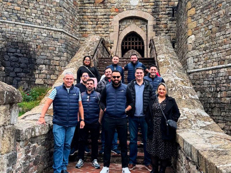 Equipe Tripla e clientes em frente a um castelo, participantes da RSA 2025